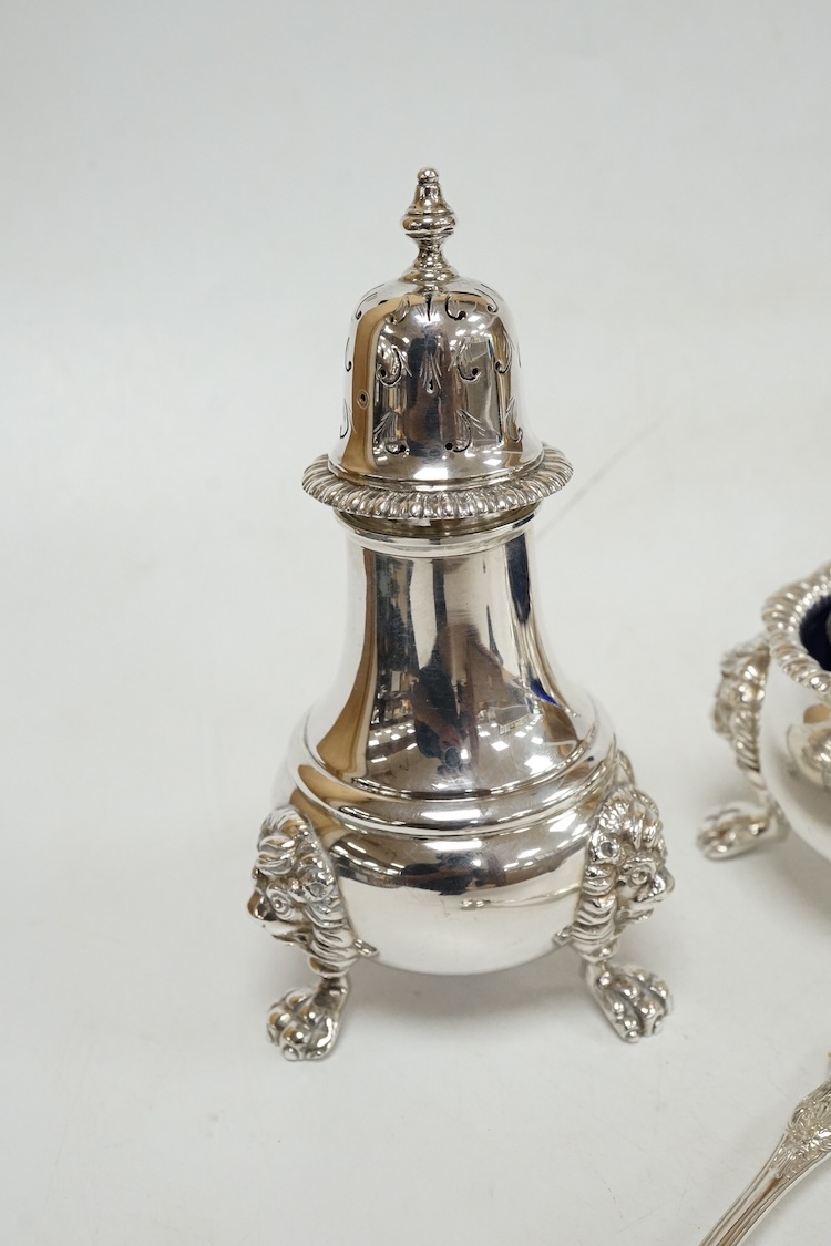 A George VI silver three piece condiment set by Mappin & Webb, London, 1937, with blue glass liners, one associated, pepper, 13.9cm, 26.5oz.